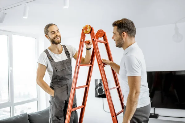 Twee werklieden aan het praten tijdens een reparatie thuis — Stockfoto