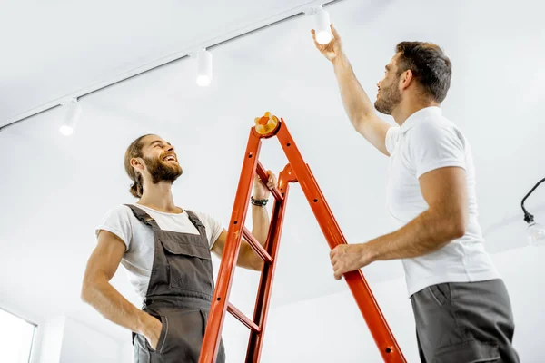 Män som installerar lampor hemma — Stockfoto