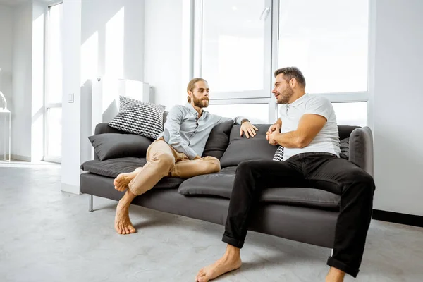 Мужчины на диване дома — стоковое фото