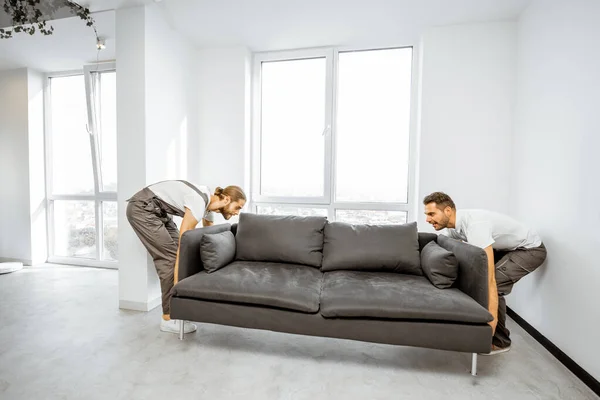 Mudanças colocando sofá em casa — Fotografia de Stock
