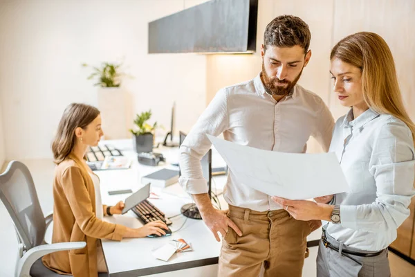 Colleagues working with an architecstural project in the office — Stock Photo, Image