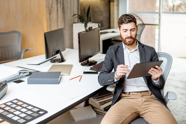 Man working on the digital tablet in the office