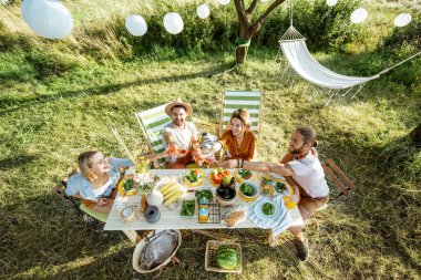 Dostlar bahçede şenlikli bir öğle yemeği yerken