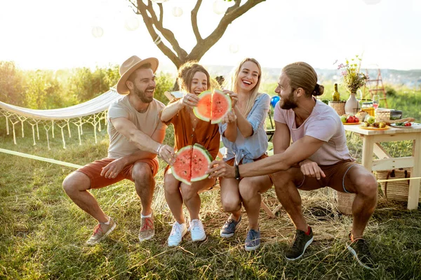 Přátelé s melounem na pikniku — Stock fotografie