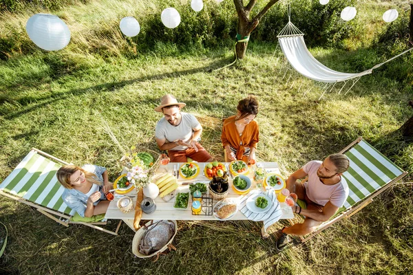 Přátelé při slavnostním obědě na zahradě — Stock fotografie