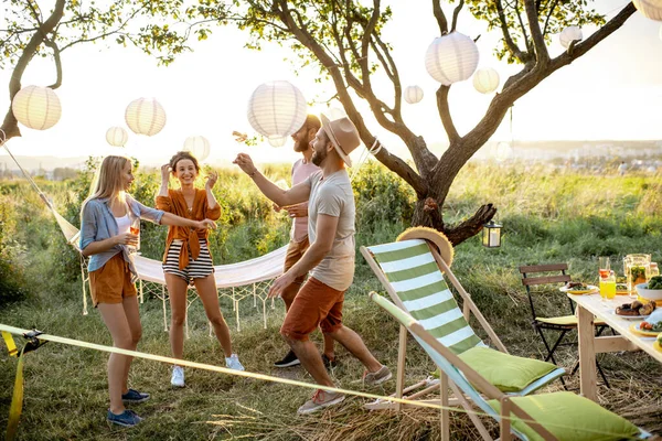 Vrienden dansen op een picknick in de tuin — Stockfoto