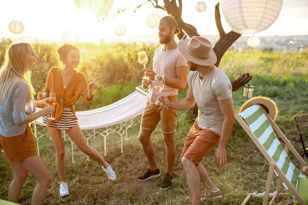 Arkadaşlar bahçede piknikte dans ediyorlar. — Stok fotoğraf