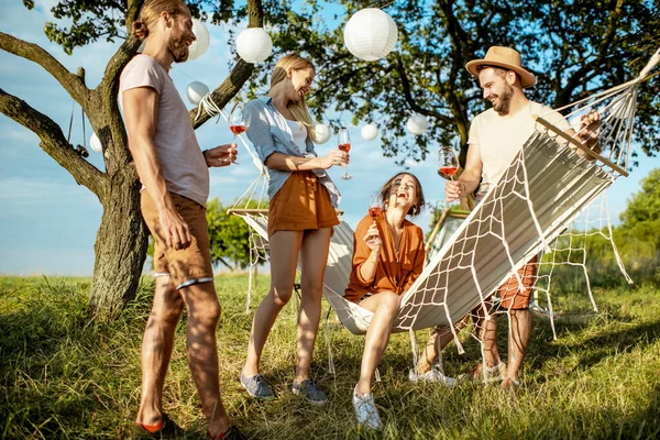 Vänner kopplar av med drinkar i trädgården — Stockfoto