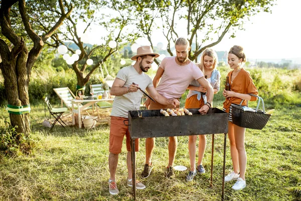 Amigos fazendo churrasco no jardim — Fotografia de Stock