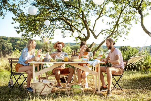 Vrienden tijdens een feestelijke lunch in de tuin — Stockfoto