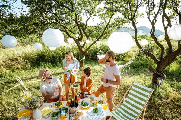 Přátelé při slavnostním obědě na zahradě — Stock fotografie