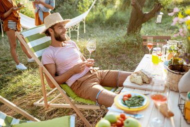 Dostlar bahçede şenlikli bir öğle yemeği yerken