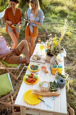 Dostlar bahçede şenlikli bir öğle yemeği yerken