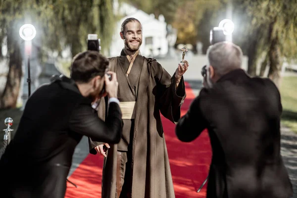 Film actor with photographers on the red carpet outdoors — Stock Photo, Image