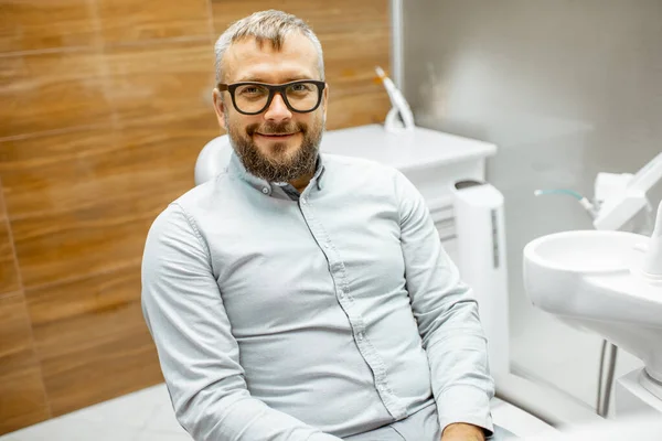 Diş muayenehanesinde hasta olarak yakışıklı bir adam. — Stok fotoğraf