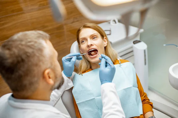 Mulher durante uma inspeção dentária no consultório odontológico — Fotografia de Stock