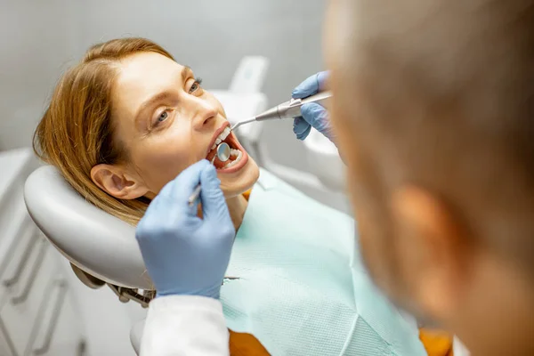Mulher durante uma inspeção dentária no consultório odontológico — Fotografia de Stock