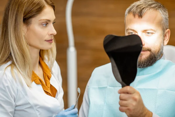 Fogászati tükörrel rendelkező páciens a fogorvosi rendelőben — Stock Fotó