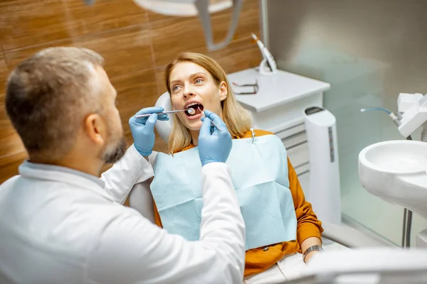 Mulher durante uma inspeção dentária no consultório odontológico — Fotografia de Stock