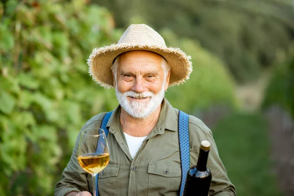 Viticoltore senior con vino in vigna — Foto Stock