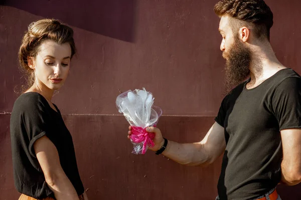 Homme donnant un bouquet fait d'ordures plastiques à une femme — Photo