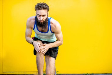 Sarı arka planda eski moda bir koşucunun portresi.