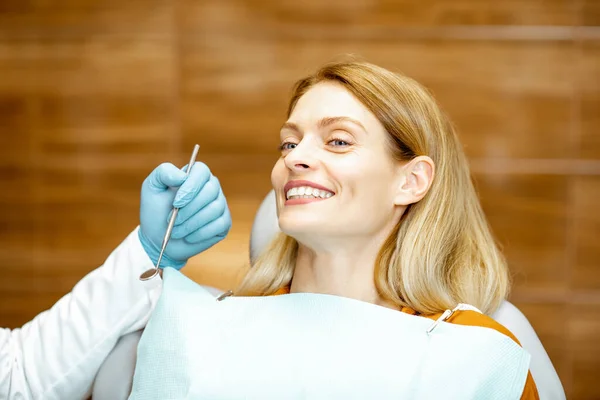 Веселая женщина на стоматологическом стуле — стоковое фото