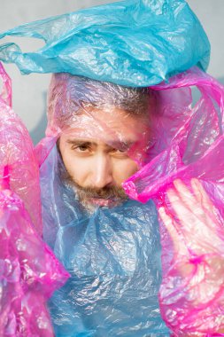 Plastik torbalarla kaplı bir adamın kavramsal portresi.