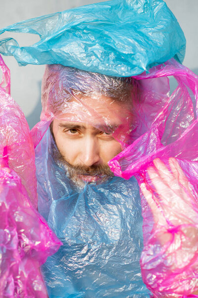 Концептуальный портрет человека, покрытый пластиковыми пакетами
