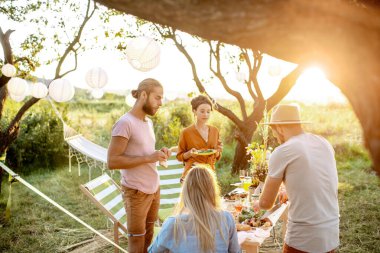 Dışarıda şenlikli bir öğle yemeği yiyen arkadaşlar.