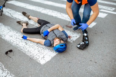 Yaralı bisikletçi ve ilk yardım sağlayan adamla trafik kazası.