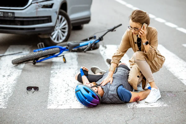 Road accident with injured cyclist and car driver — Stock Photo, Image