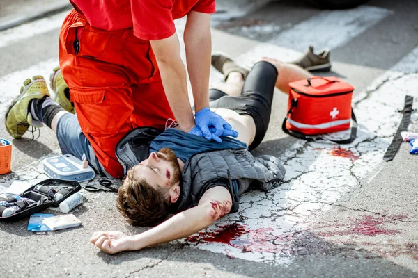 Médico que aplica cuidados de emergência após o acidente de viação — Fotografia de Stock