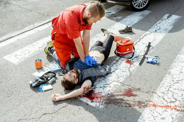 Médico aplicando atención de emergencia después del accidente de tráfico —  Fotos de Stock