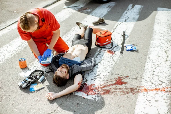 Médico aplicando atención de emergencia después del accidente de tráfico —  Fotos de Stock