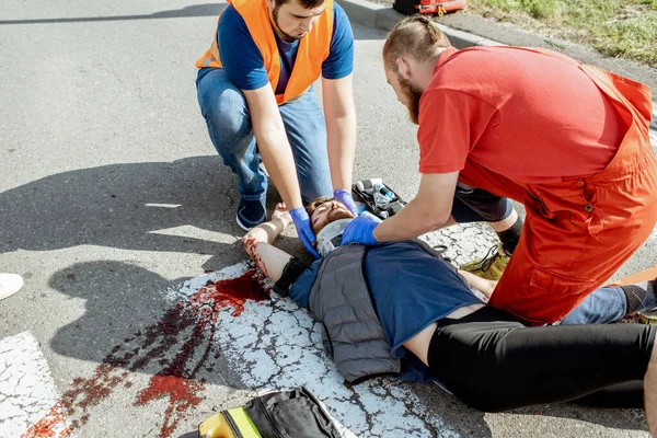 Sürgősségi ellátásban részesítik a sérültet az úton. — Stock Fotó