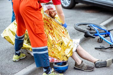 Kazadan sonra kurbanın üstünü termal battaniyeyle örten doktor.