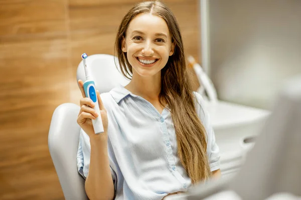 Junge Patientin mit Zahnbürste in der Zahnarztpraxis — Stockfoto