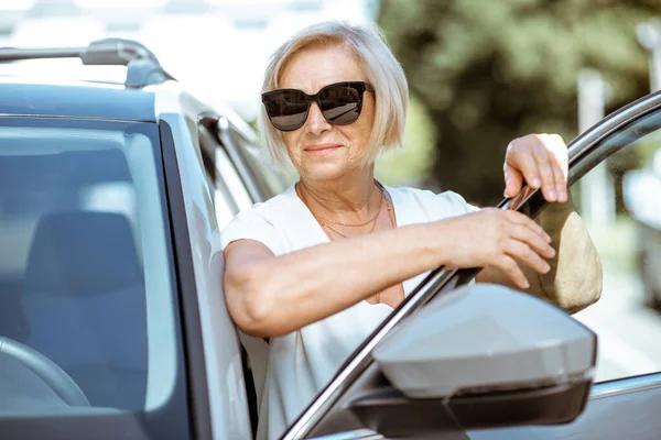 Portrét starší ženy poblíž auta — Stock fotografie