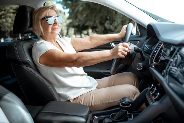 Starší žena řídit auto — Stock fotografie