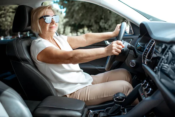 Seniorin fährt Auto — Stockfoto