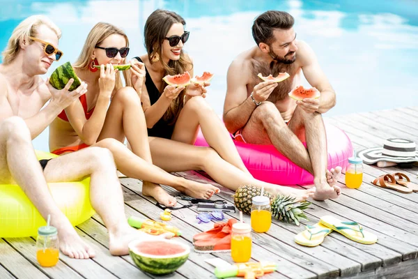 Amigos com melancia na piscina ao ar livre — Fotografia de Stock