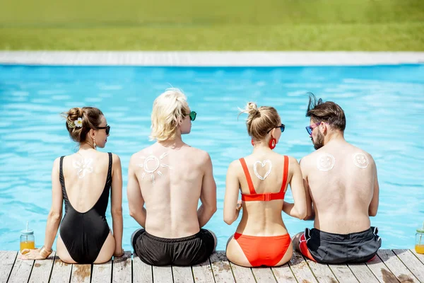 Friends with sun cream on the swimming pool outdoors — Stock Photo, Image