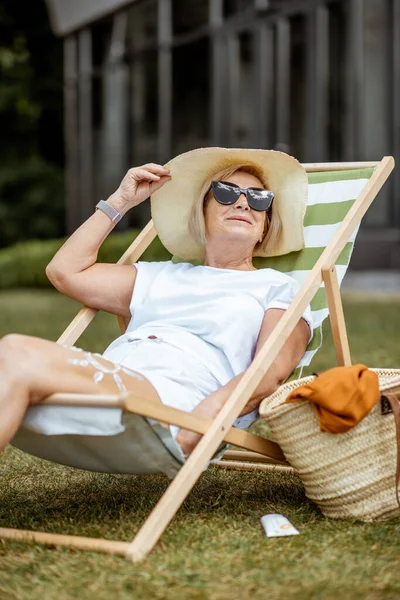 Oudere vrouw op de zonnebank buiten — Stockfoto
