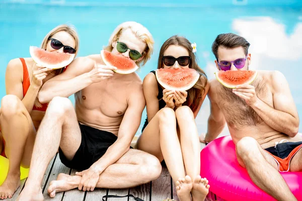 Amigos com melancia na piscina ao ar livre — Fotografia de Stock