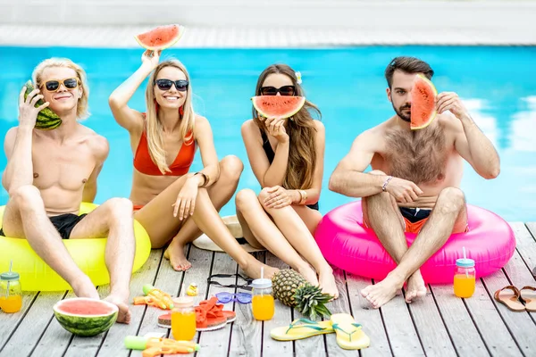 Amigos com melancia na piscina ao ar livre — Fotografia de Stock
