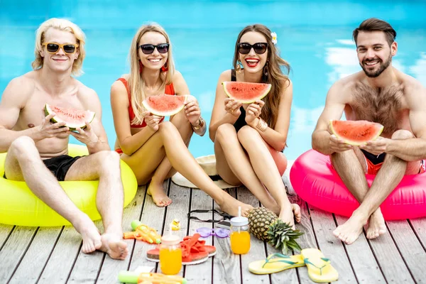Amis avec pastèque sur la piscine en plein air — Photo