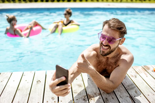 Man with phone in the swimming pool