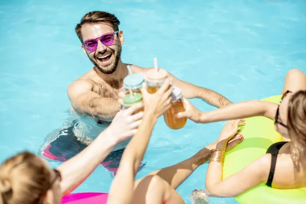 Amis avec des boissons dans la piscine — Photo