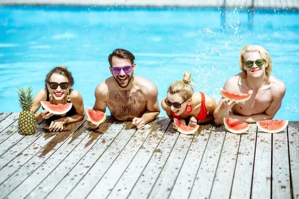 Amis avec pastèque sur la piscine en plein air — Photo